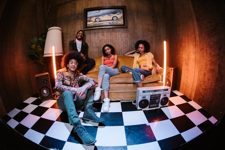 A diverse group of young adults enjoying a stylish retro-themed room with neon lights.